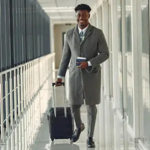 a black man walking with a luggae