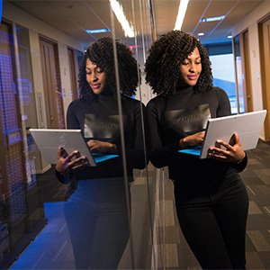 A Black woman holding a laptop