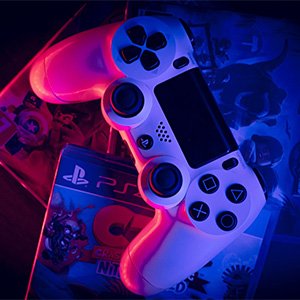 A Sony Playstation game controller on top of PS4 games