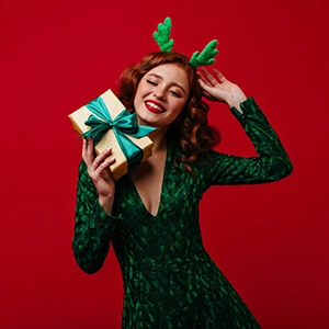 woman holding a gift package and wearing a green dress